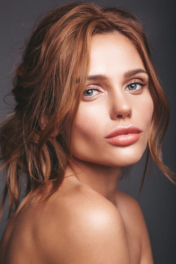 A beautiful woman with red hair and blue eyes.