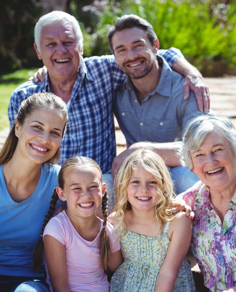 A family is sitting on a bench and smiling, showcasing their close-knit bond in a heartwarming Family-Based moment.