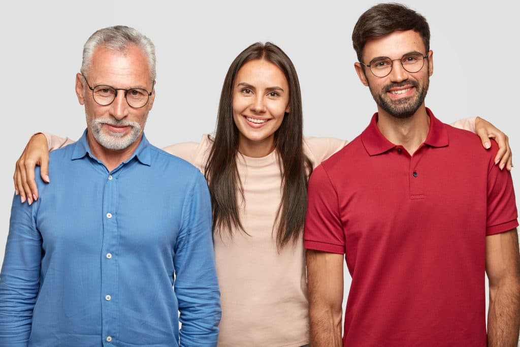 Um grupo de pessoas posando em frente a um fundo cinza.