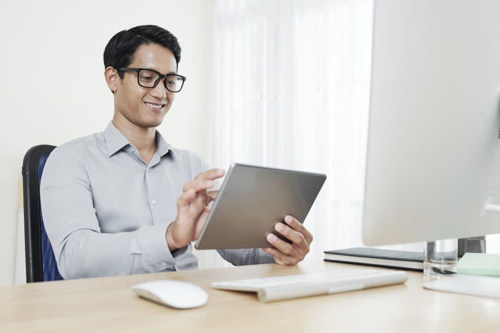 Empresário asiático usando um tablet no escritório.