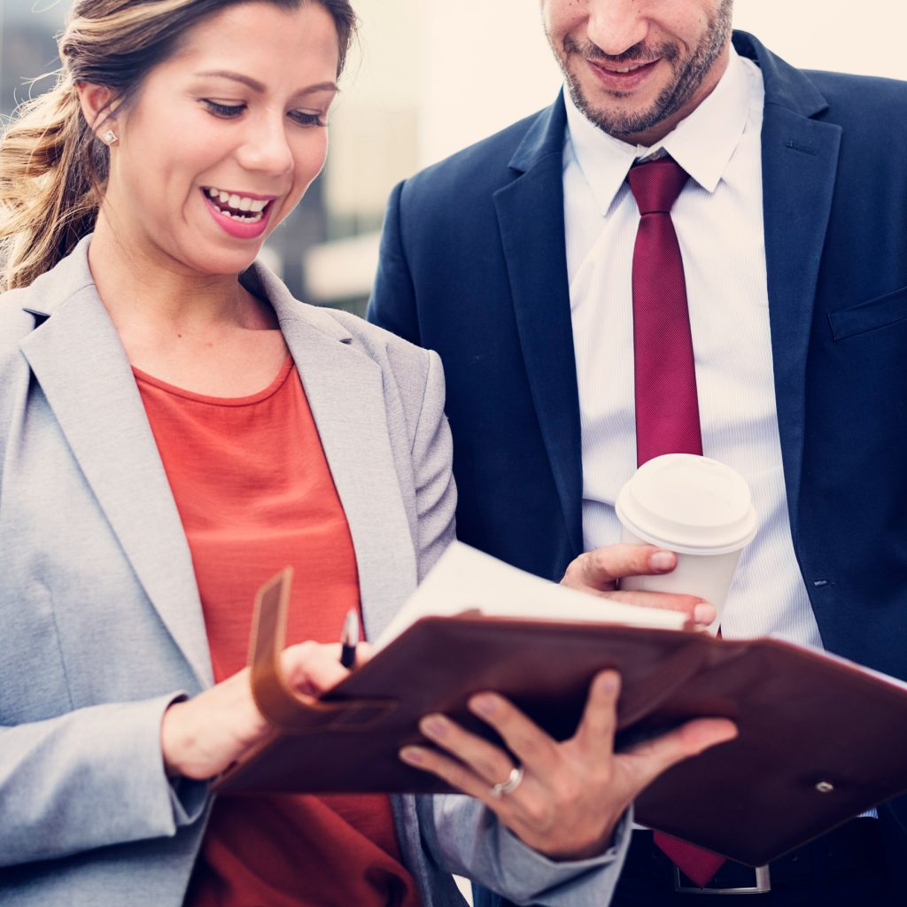 A man and a woman holding a folder.