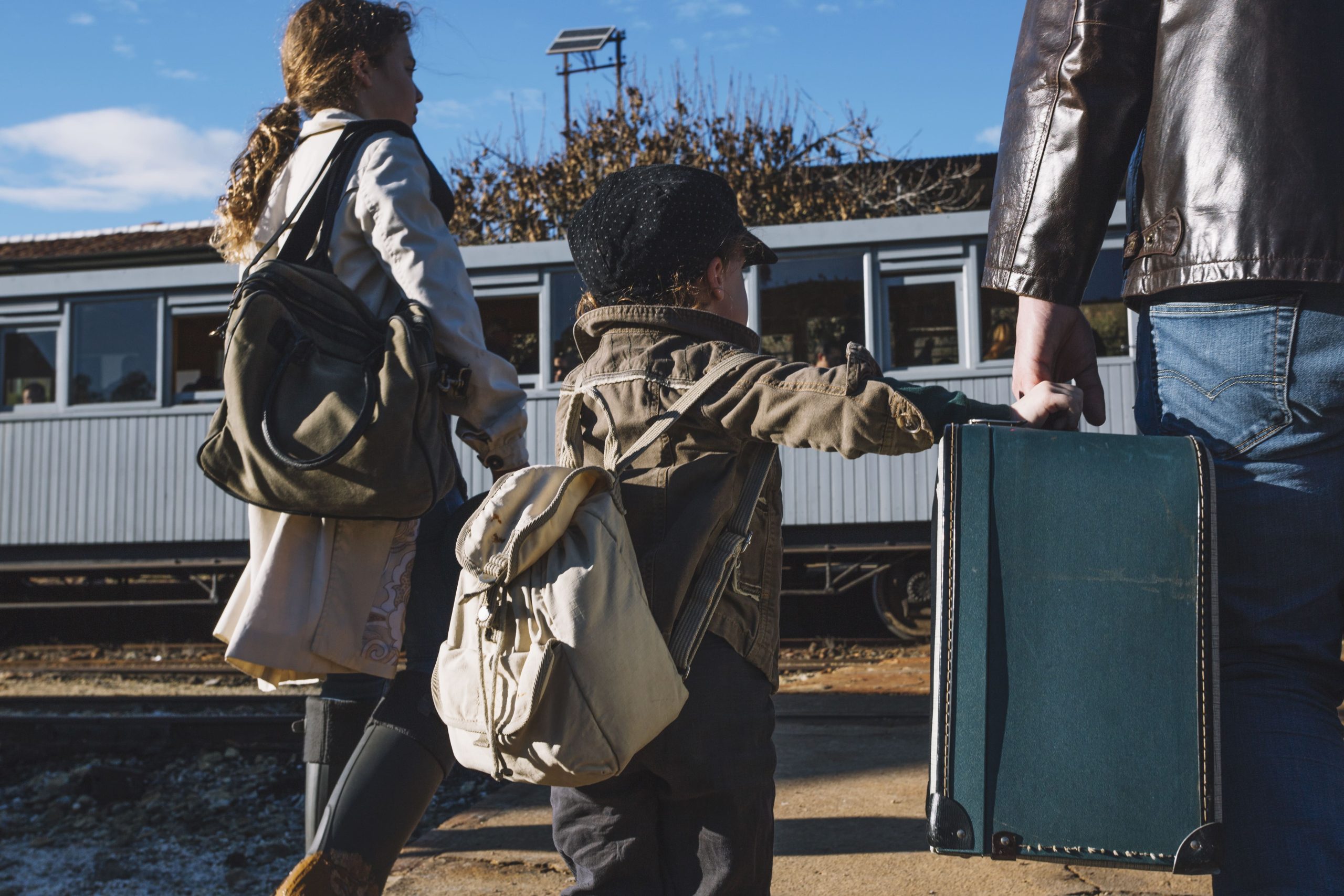 A man, woman, and child are standing next to a train.