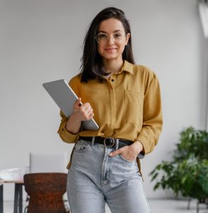 Uma jovem segurando um tablet em um escritório.