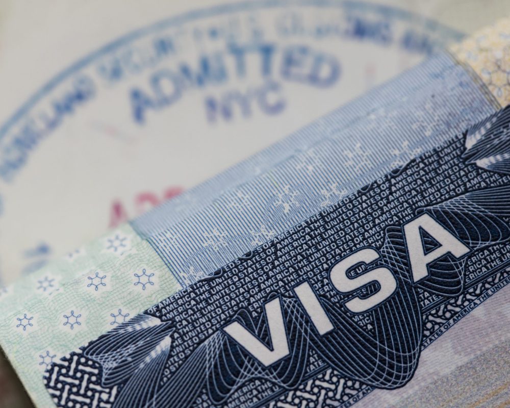 Um close de um visto e um passaporte.