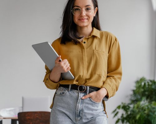 Uma jovem segurando um tablet em um escritório. Uma jovem segurando um tablet em um escritório.